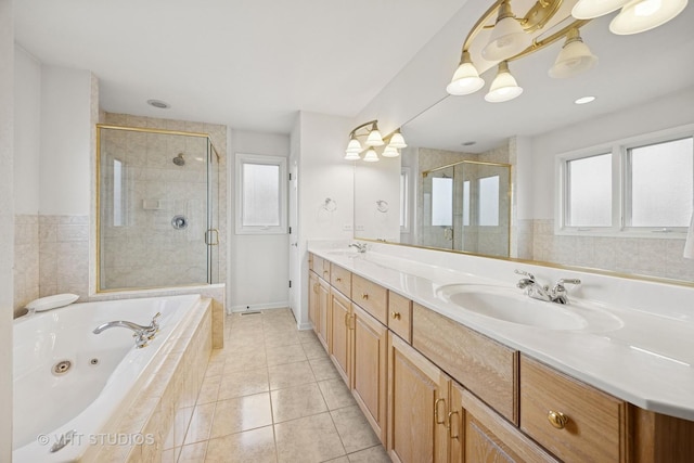 full bath featuring a tub with jets, a wealth of natural light, tile patterned flooring, and a sink