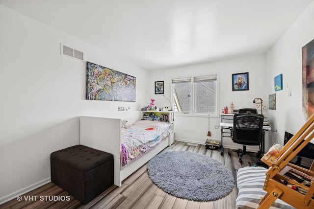 bedroom featuring visible vents, wood finished floors, and baseboards