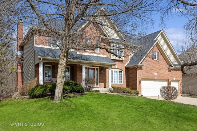 traditional home featuring an attached garage, a chimney, concrete driveway, a front yard, and brick siding