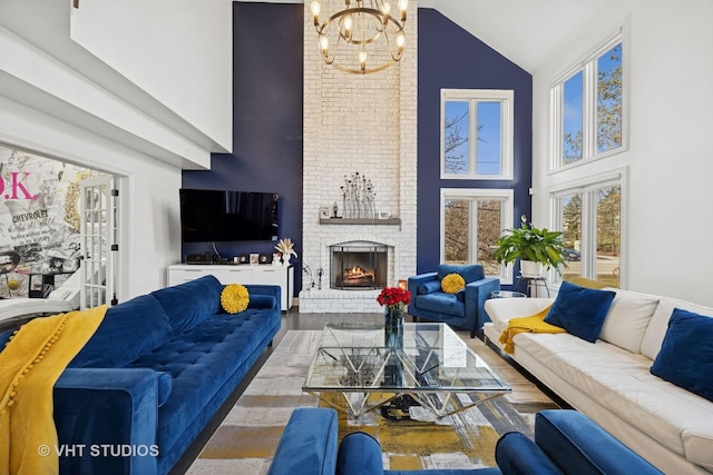 living room with an inviting chandelier, wood finished floors, a fireplace, and high vaulted ceiling