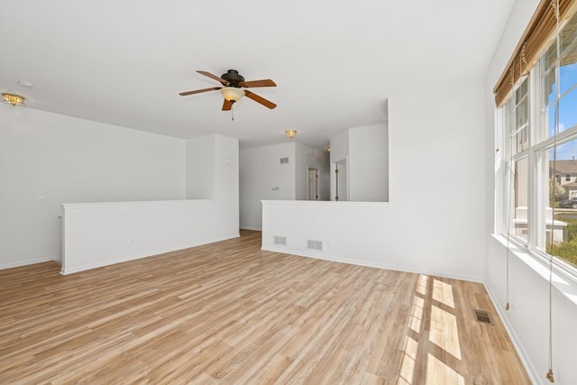 spare room with visible vents, a healthy amount of sunlight, light wood finished floors, and ceiling fan