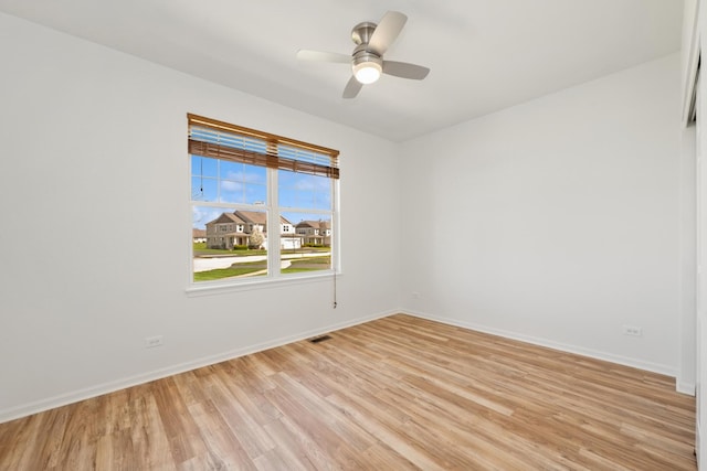 unfurnished room featuring a ceiling fan, visible vents, light wood-style flooring, and baseboards