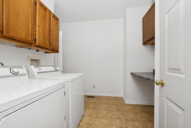 laundry room with baseboards, cabinet space, and washing machine and clothes dryer
