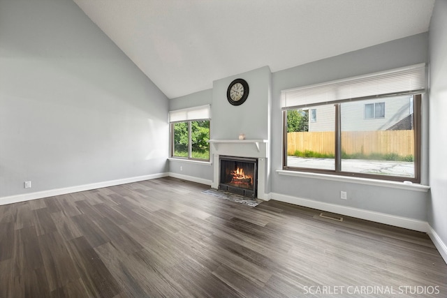 516 Gardiner Ct, Romeoville, IL 60446 - unfurnished living room with dark wood-style floors, a fireplace with flush hearth, baseboards, and high vaulted ceiling