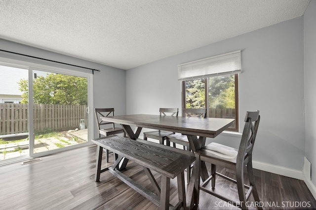516 Gardiner Ct, Romeoville, IL 60446 - dining area with healthy amount of natural light, dark wood-style flooring, a textured ceiling, and baseboards