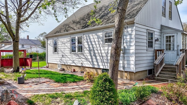 view of side of property with a shingled roof and entry steps