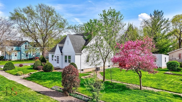 view of side of home with a lawn and roof with shingles