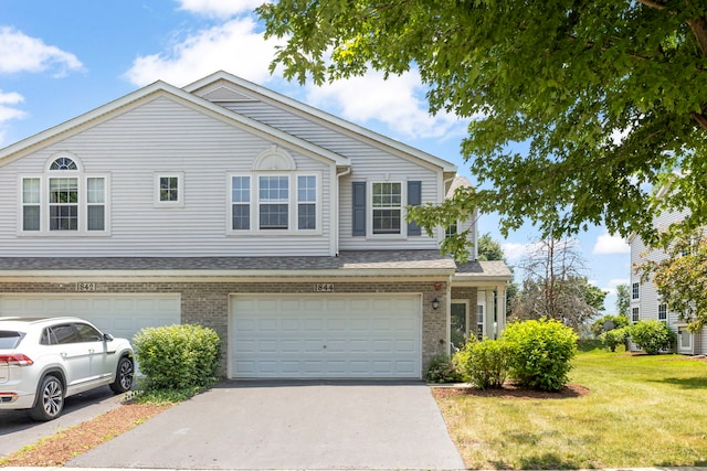1844 Candlelight Cir, Montgomery, IL 60538 - view of front of house with a front lawn, driveway, brick siding, and a garage