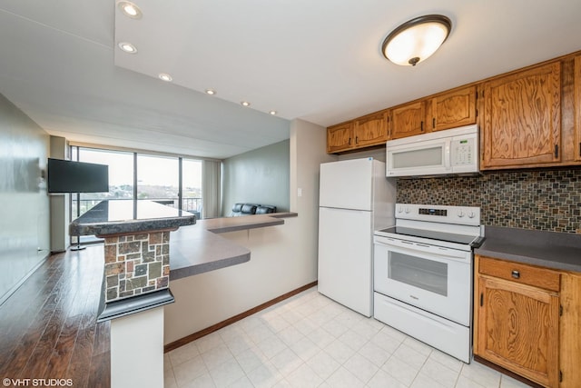 2005 S Finley Rd Unit 611, Lombard, IL 60148 - kitchen featuring white appliances, tasteful backsplash, brown cabinetry, baseboards, and dark countertops