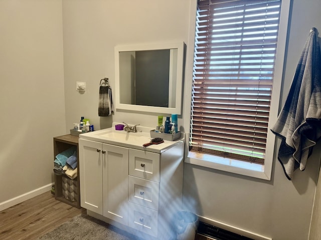 bathroom with plenty of natural light, baseboards, wood finished floors, and vanity