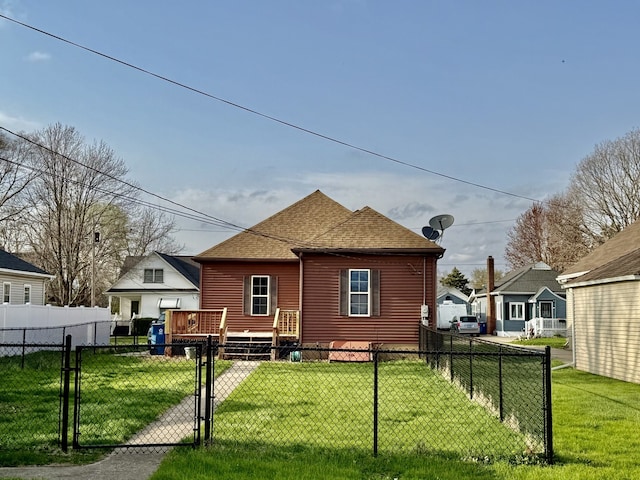 back of house with fence private yard, a gate, a yard, and roof with shingles