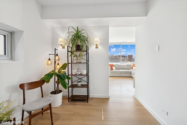 corridor with light wood-type flooring and baseboards