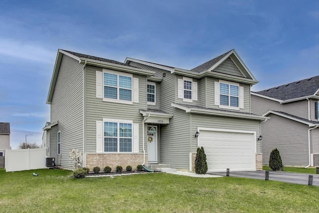 view of front of property with driveway, fence, brick siding, a garage, and a front yard