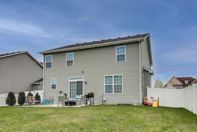 back of house with a patio area, a lawn, and a fenced backyard