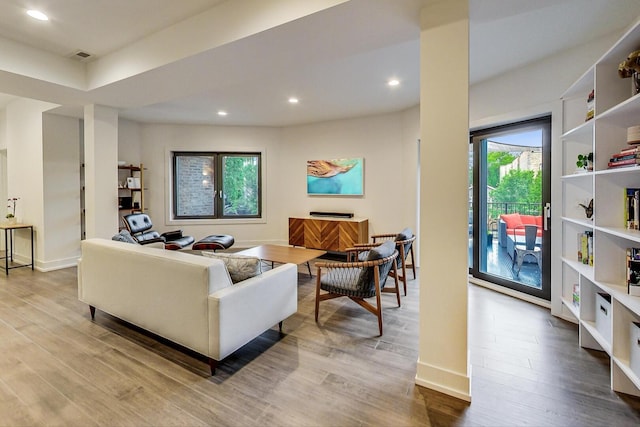 living room with visible vents, baseboards, wood finished floors, and recessed lighting