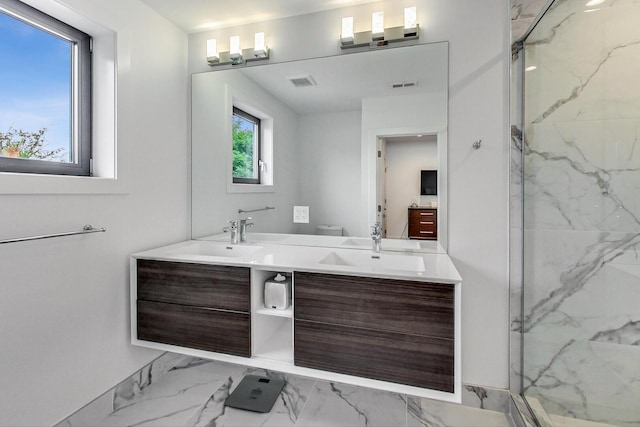 bathroom featuring marble finish floor, a sink, and a marble finish shower