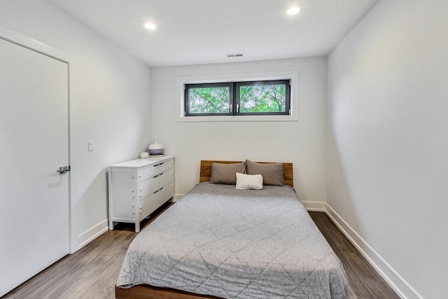bedroom featuring visible vents, baseboards, recessed lighting, and wood finished floors