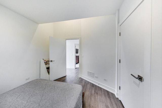 bedroom with dark wood finished floors and visible vents