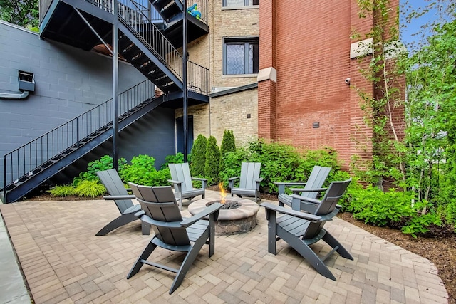 view of patio / terrace featuring an outdoor fire pit and stairway