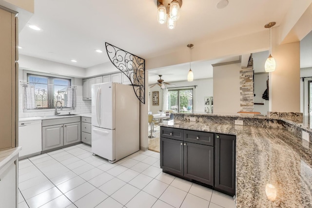 kitchen with a sink, white appliances, a ceiling fan, decorative backsplash, and pendant lighting
