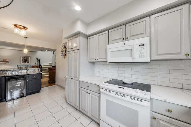 kitchen with gray cabinets, tasteful backsplash, light tile patterned floors, beverage cooler, and white appliances