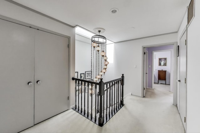 corridor featuring light colored carpet, baseboards, visible vents, and an upstairs landing