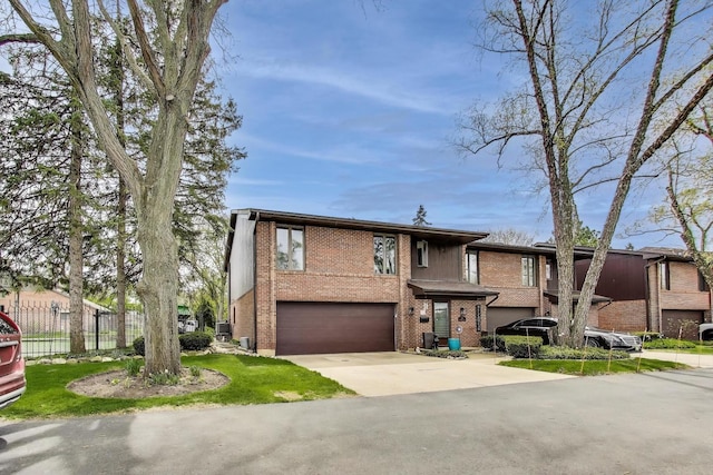 view of front of home featuring a garage, fence, driveway, and brick siding