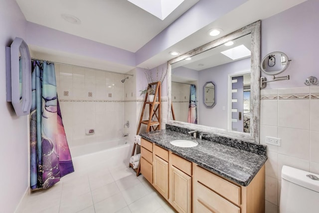 full bath with a skylight, shower / tub combo, tile patterned floors, vanity, and toilet
