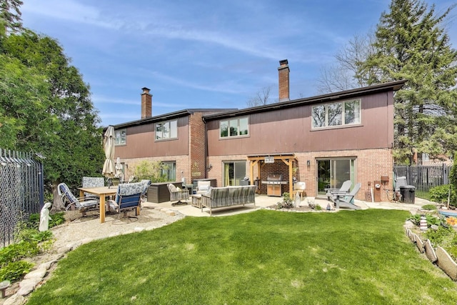 rear view of house with fence, brick siding, an outdoor hangout area, a chimney, and a lawn