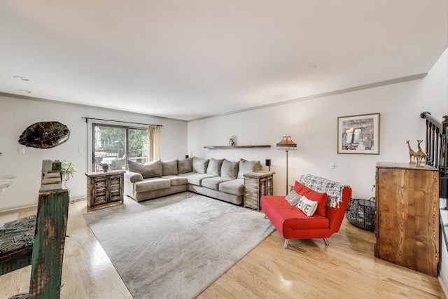 living area featuring crown molding and light wood finished floors