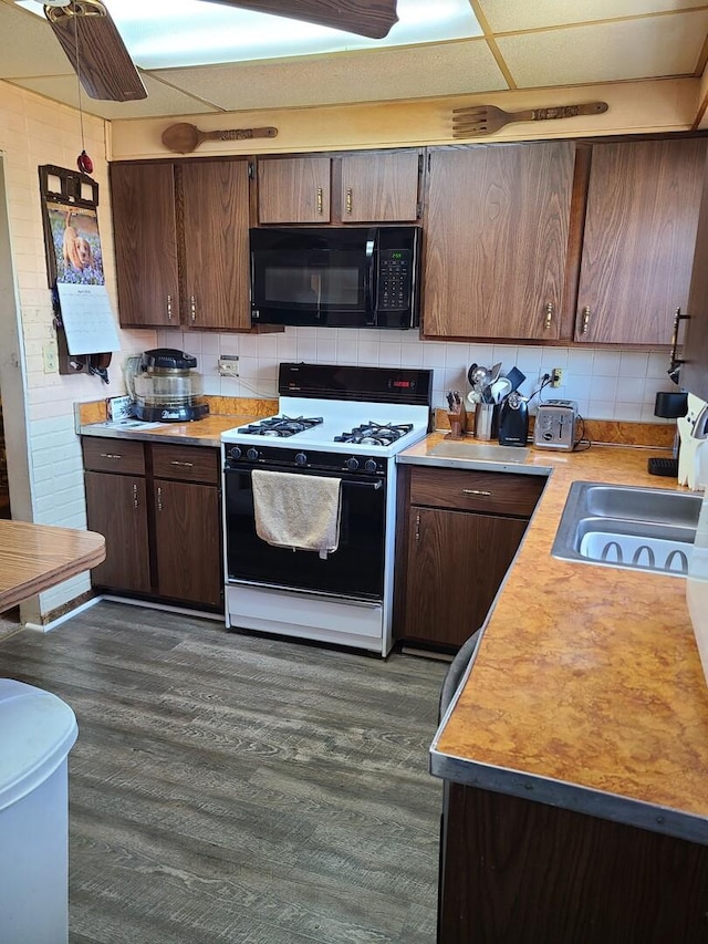 128 Whitehall Ave, Northlake, IL 60164 - kitchen with a sink, backsplash, range with gas stovetop, black microwave, and light countertops