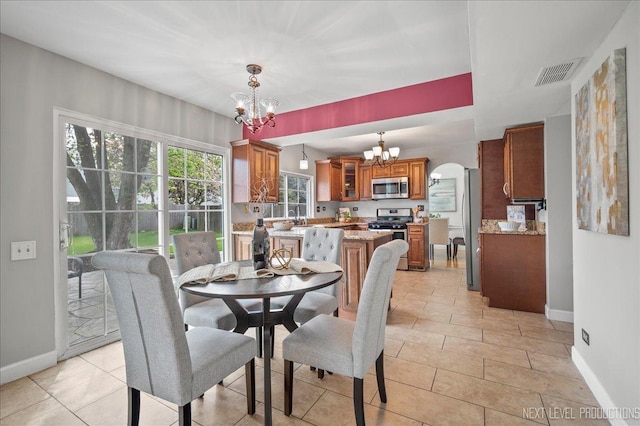dining room featuring arched walkways, baseboards, an inviting chandelier, and visible vents