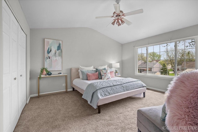 bedroom with carpet flooring, baseboards, lofted ceiling, and a closet