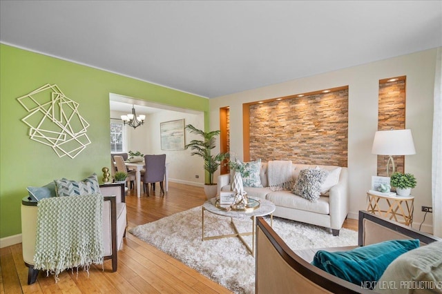 living room with an inviting chandelier, baseboards, and hardwood / wood-style flooring