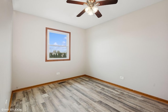 spare room with baseboards, a ceiling fan, and wood finished floors