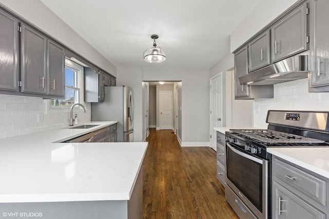 kitchen with under cabinet range hood, appliances with stainless steel finishes, gray cabinetry, and a sink