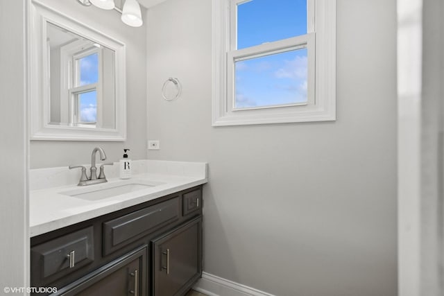 bathroom featuring plenty of natural light, baseboards, and vanity