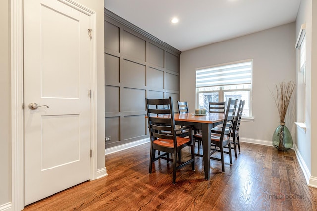 dining space with baseboards, wood finished floors, and recessed lighting