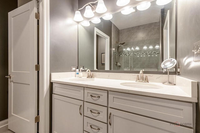 bathroom with a sink, a shower stall, and double vanity