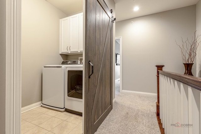 washroom with a barn door, washer and clothes dryer, cabinet space, baseboards, and recessed lighting