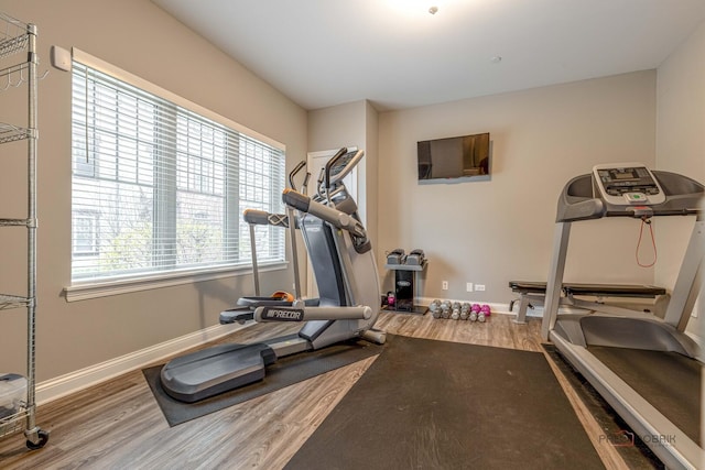 exercise room featuring baseboards and wood finished floors