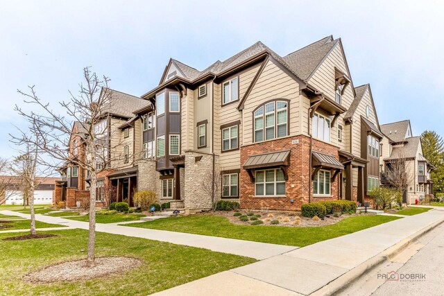 townhome / multi-family property with brick siding, a residential view, and a front lawn