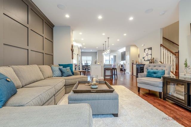 living room featuring wood finished floors, recessed lighting, and stairway