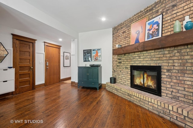 unfurnished living room with baseboards, a fireplace, recessed lighting, and wood finished floors