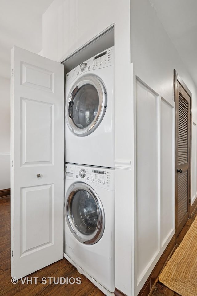 laundry room featuring stacked washer / drying machine, laundry area, and dark wood-type flooring