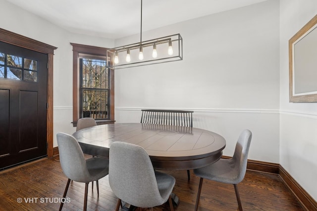 dining space featuring baseboards and dark wood-type flooring