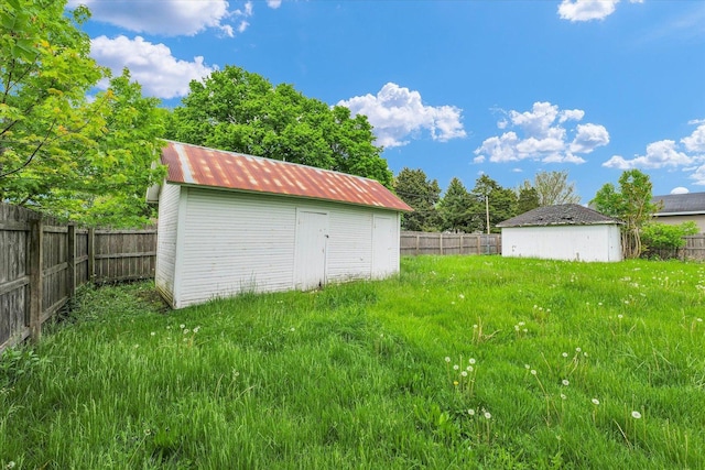 fenced backyard featuring a shed and an outbuilding