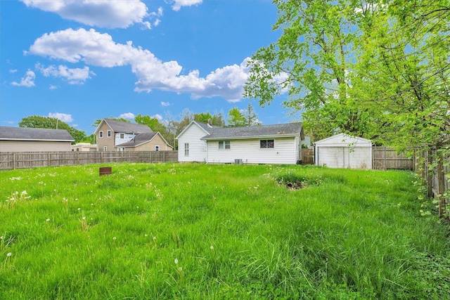 back of property with fence, a storage unit, and an outbuilding