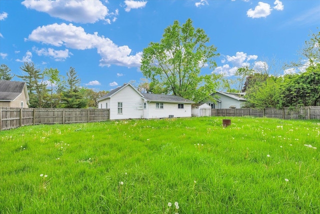 fenced backyard featuring a storage unit and an outdoor structure
