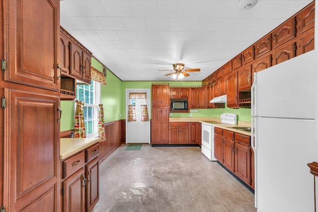 907 E Glenview Dr, Tuscola, IL 61953 - kitchen with white appliances, under cabinet range hood, ceiling fan, a wainscoted wall, and light countertops